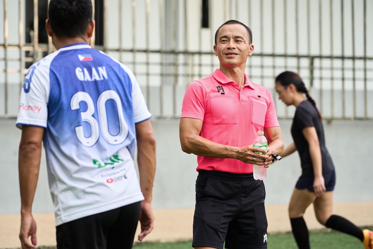 A LUMI coach speaking with a player on the training pitch